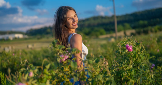 Une femme dans un champ de roses en fleurs dans la vallée des Roses bulgare
